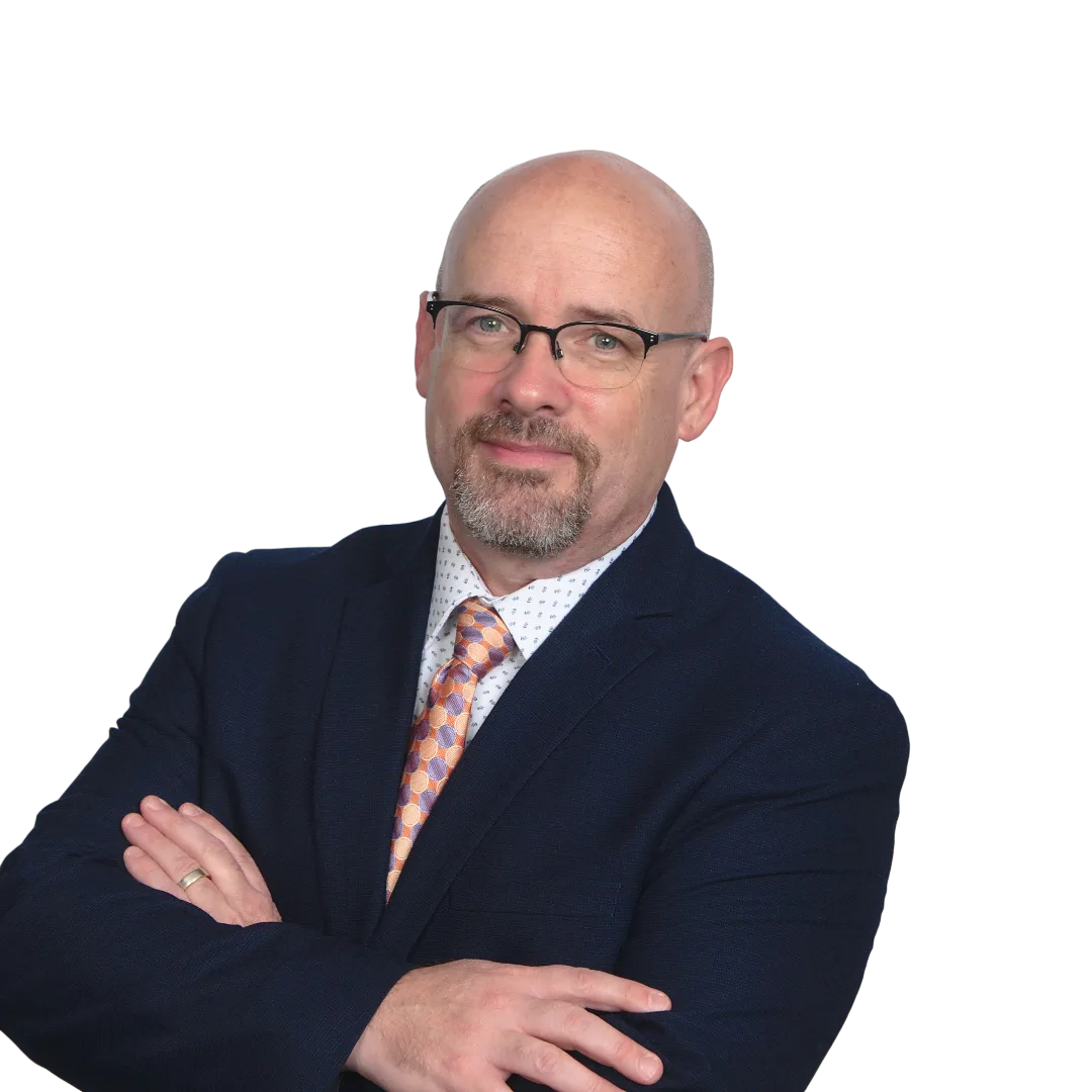 Professional man with glasses wearing dark blazer and orange patterned tie, arms crossed, against white background.